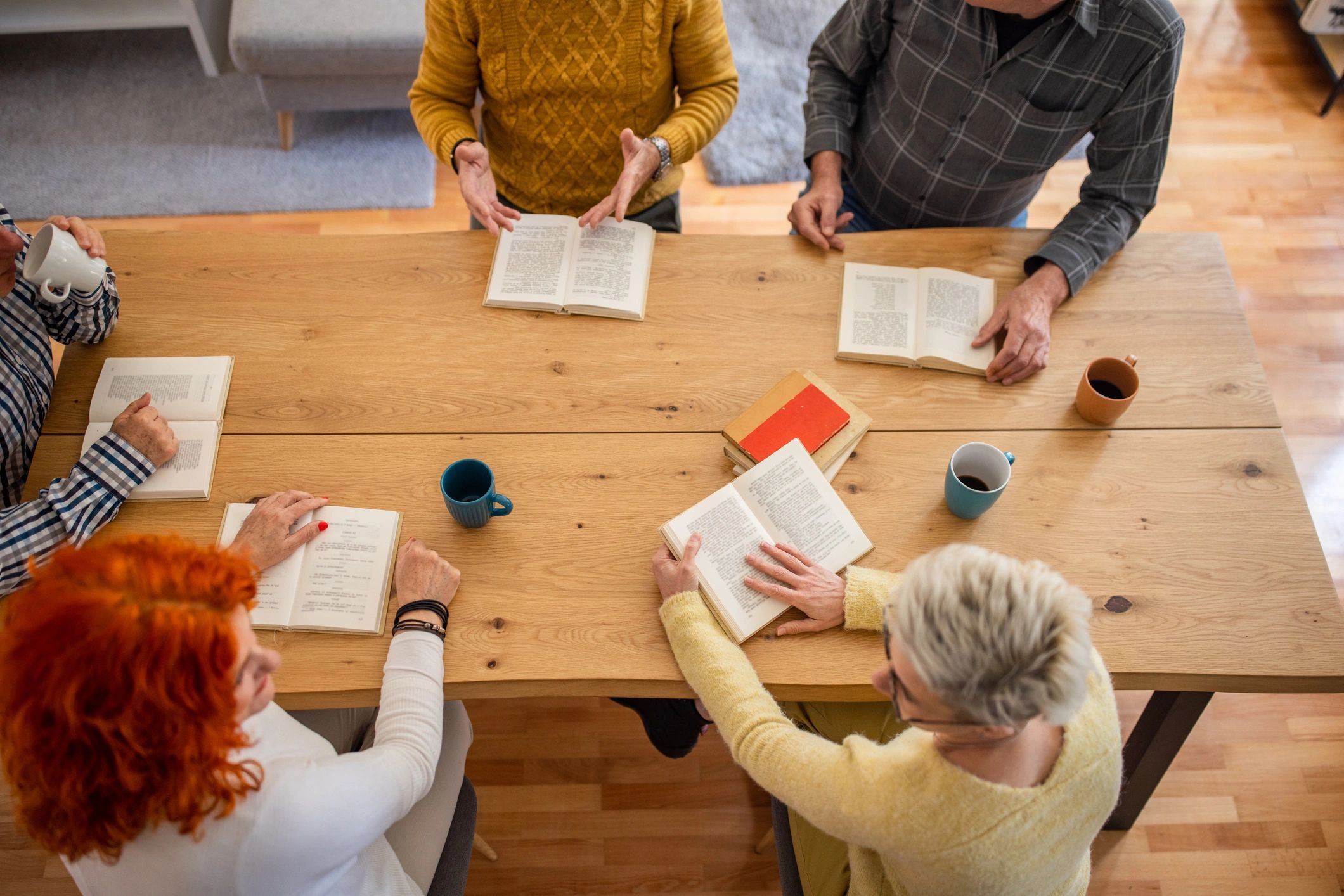 Personnes âgées lisant et discutant d’un livre ensemble